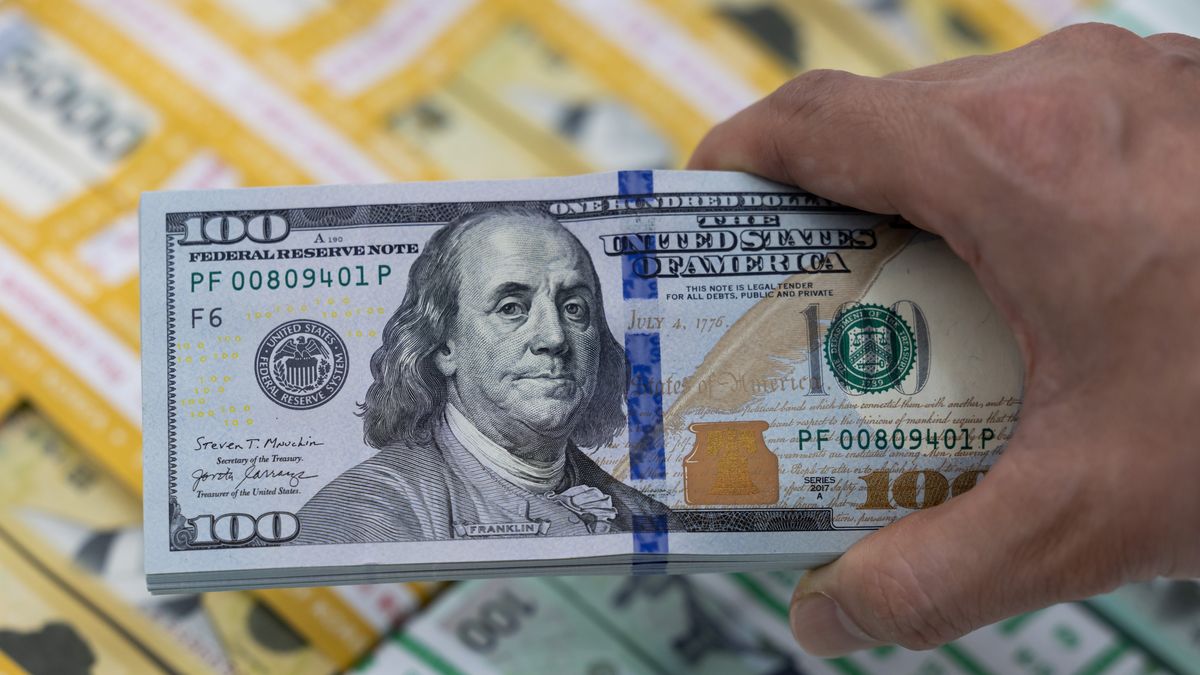 A bundle of U.S. 100 dollar banknotes and bundles of South Korean won banknotes arranged at the Shinhan Bank headquarters, a unit of Shinhan Financial Group Co., in Seoul, South Korea, on Thursday, April 18, 2024. The South Korean won slumps after Federal Reserve officials' hawkish remarks spurred a rally in the dollar overnight. Photographer: SeongJoon Cho/Bloomberg via Getty Images