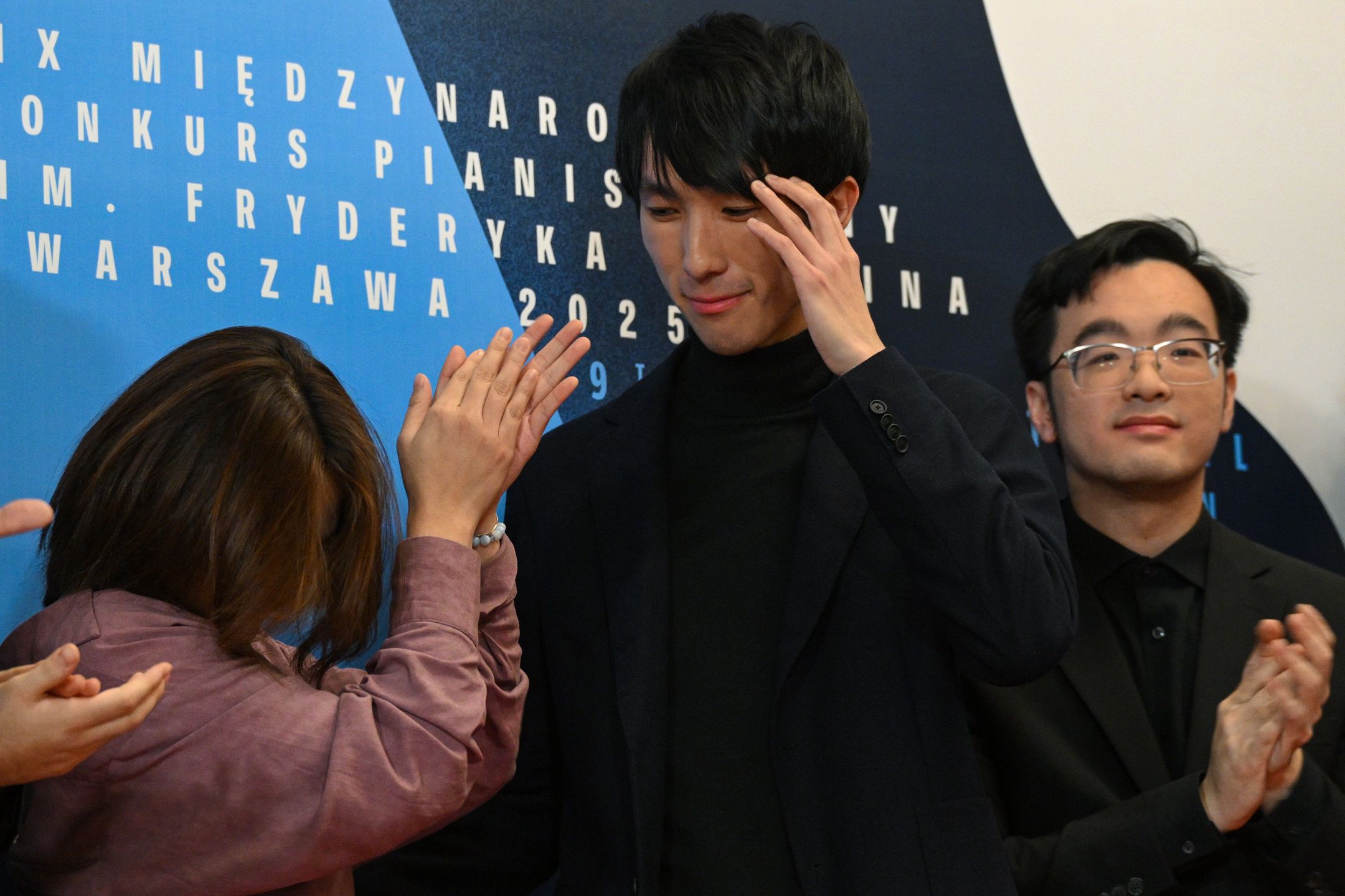 Warszawa, 21.10.2025. XIX Konkurs Chopinowski. Laureat pierwszego miejsca, Eric Lu z USA (C) podczas ogłoszenia wyników finału XIX edycji Konkursu Chopinowskiego w sali koncertowej Filharmonii Narodowej w Warszawie, w nocy z 20 na 21 bm. (amb) PAP/Radek Pietruszka