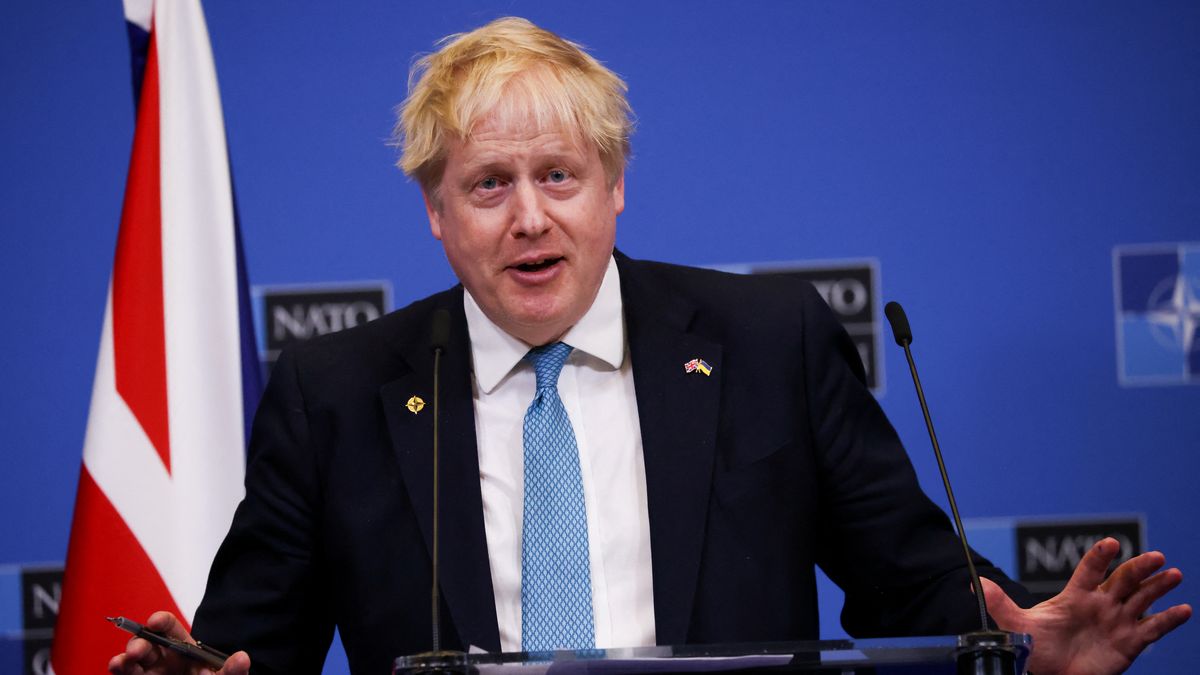 Na zdjęciu Boris Johnson na tle flagi brytyjskiej i ścianki z logo NATO