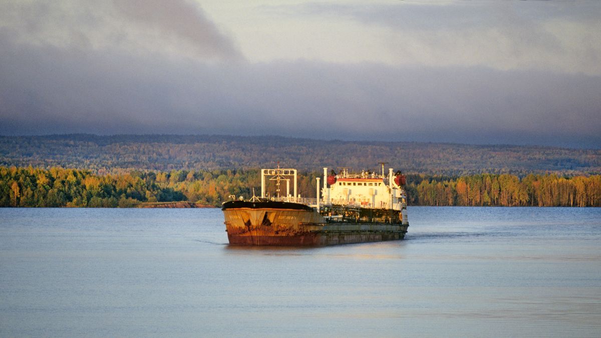 Storm clouds from a September storm sail over a remote forest and a rusty Russian oil tanker on the Volga River in inland western Russia, 1985. (Photo By Buddy Mays/Getty Images).