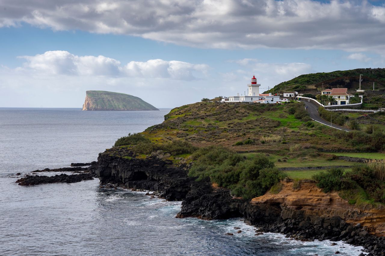 Widok z klifu na latarnię morską Ponta das Contendas w São Sebastião, na wyspie Terceira, w portugalskim archipelagu Azorów  