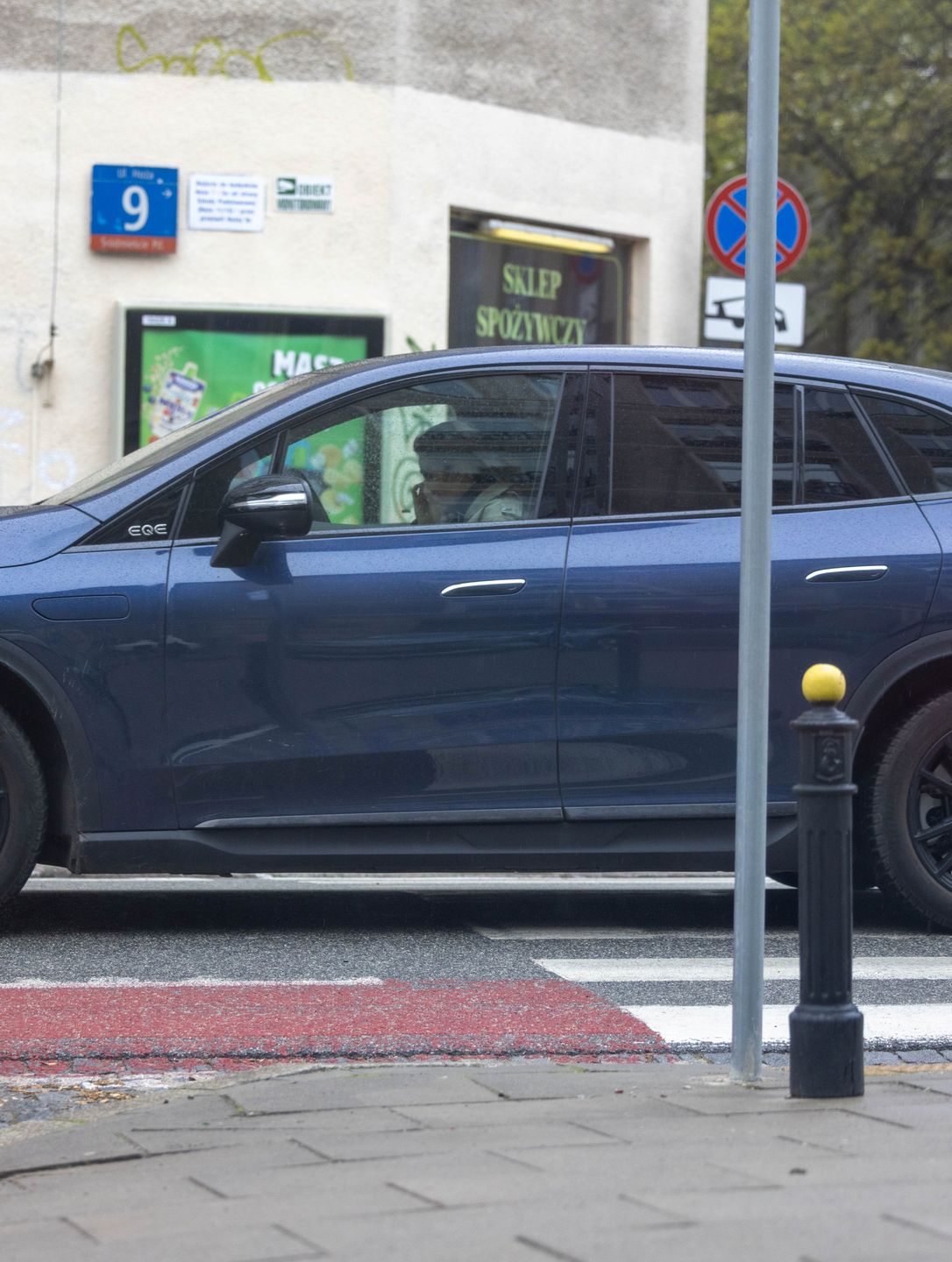 Małgorzata Socha maszeruje po deszczowej Warszawie ze smartfonem przy uchu