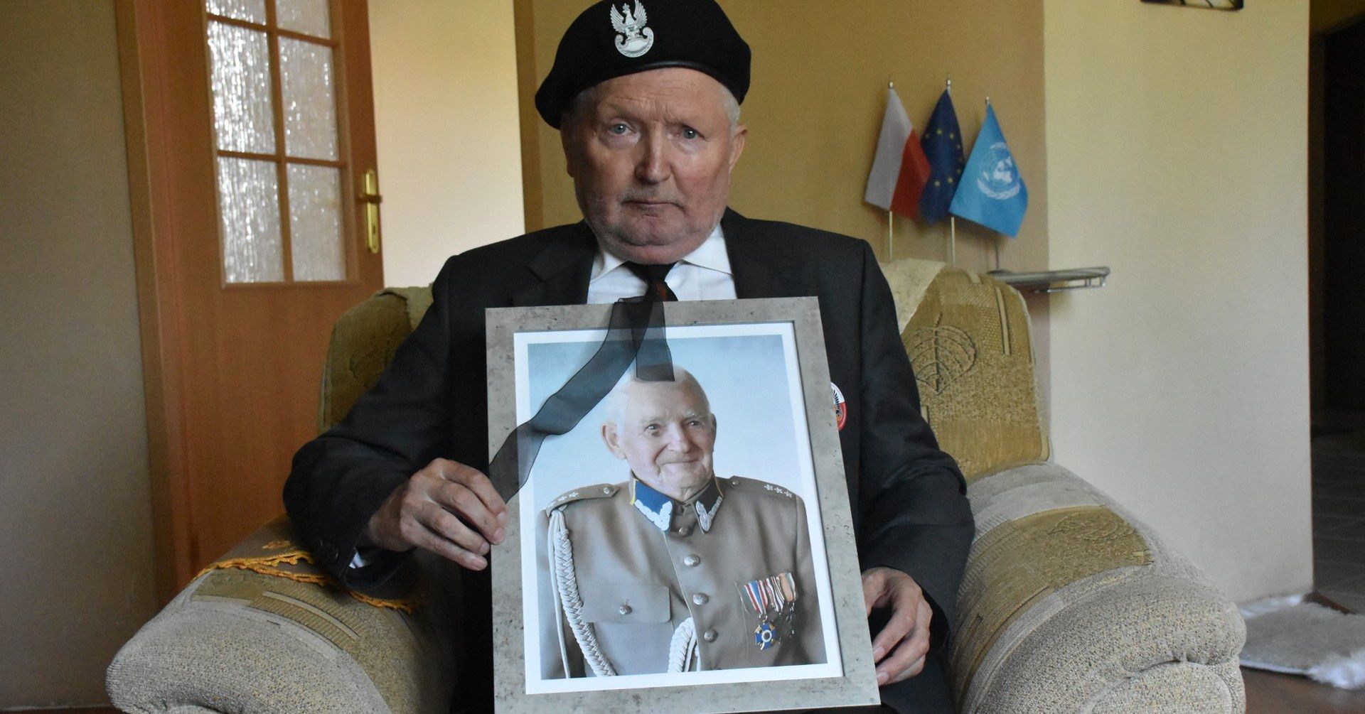 Marian Kwidziński z Białogardu trzymający fotografie nieżyjącego ojca