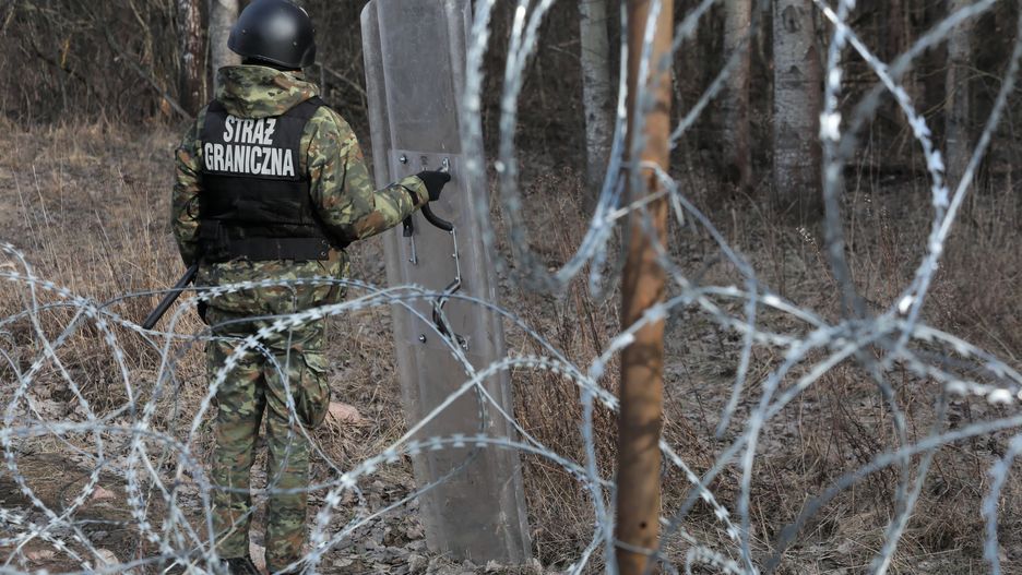 Funkcjonariusz straży granicznej w miejscu budowy zapory przy polsko-białoruskiej granicy