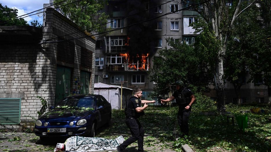 arch51
EDITORS NOTE: Graphic content / TOPSHOT - Policemen react next to an injured person lying on the ground in front of a burning building after an air strike hit the courtyard of civilian residences in the centre of Kramatorsk, eastern Ukraine, on July 19, 2022, amid the Russian invasion of Ukraine. (Photo by MIGUEL MEDINA / AFP)
MIGUEL MEDINA