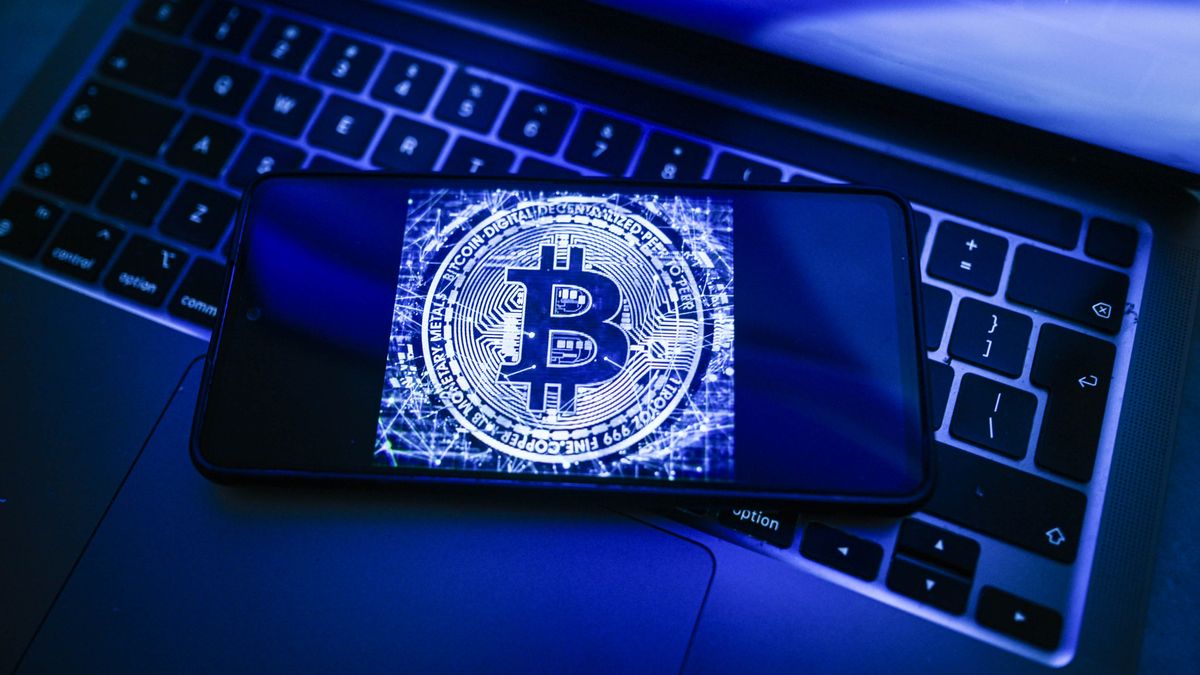 POLAND - 2026/07/20: In this photo illustration, a Bitcoin logo is seen displayed on a smartphone on the top of a laptop. (Photo Illustration by Omar Marques/SOPA Images/LightRocket via Getty Images)