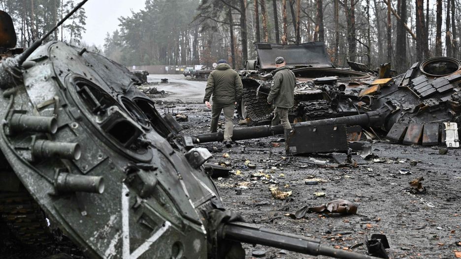 arch50TOPSHOT - Ukrainian servicemen walk next to destroyed Russian tanks and armored personnel carriers (APC) in Dmytrivka village, west of Kyiv, on April 2, 2022 as Ukraine says Russian forces are making a "rapid retreat" from northern areas around Kyiv and the city of Chernigiv. (Photo by Genya SAVILOV / AFP)GENYA SAVILOV