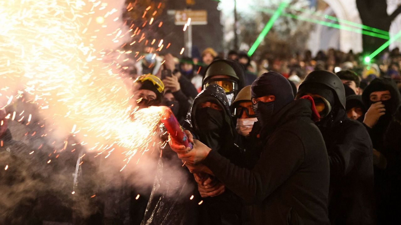 Protestujący odpalają race w czasie demonstracji. Tbilisi, 2 grudnia 2024 roku