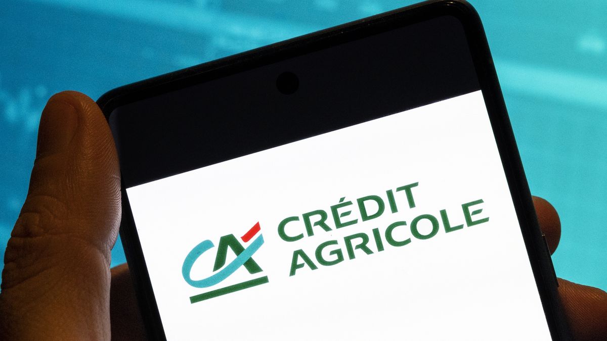CHINA - 2023/02/19: In this photo illustration, the French worlds largest cooperative financial institution Credit Agricole logo is seen displayed on a smartphone with an economic stock exchange index graph in the background. (Photo Illustration by Budrul Chukrut/SOPA Images/LightRocket via Getty Images)