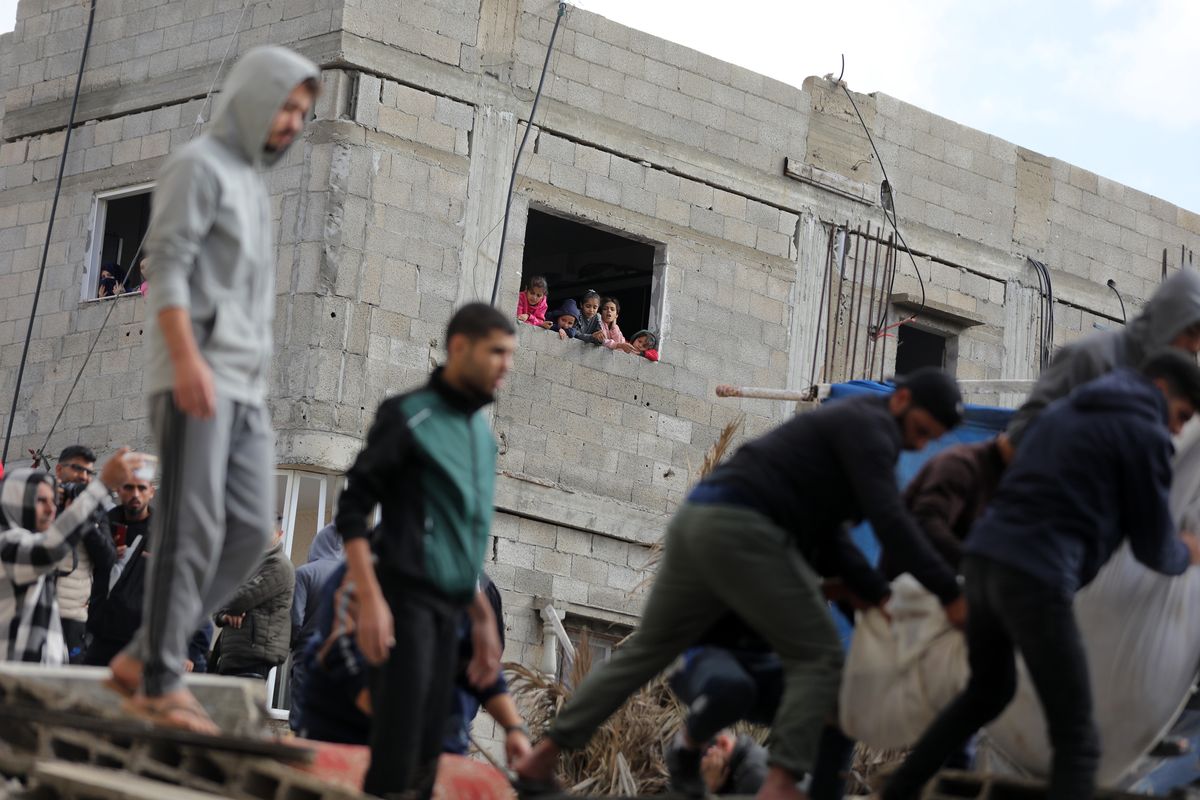 Palestyńczycy niosą osobę ranną w wyniku izraelskiego ostrzału w Deir el-Balah w środkowej Strefie Gazy 