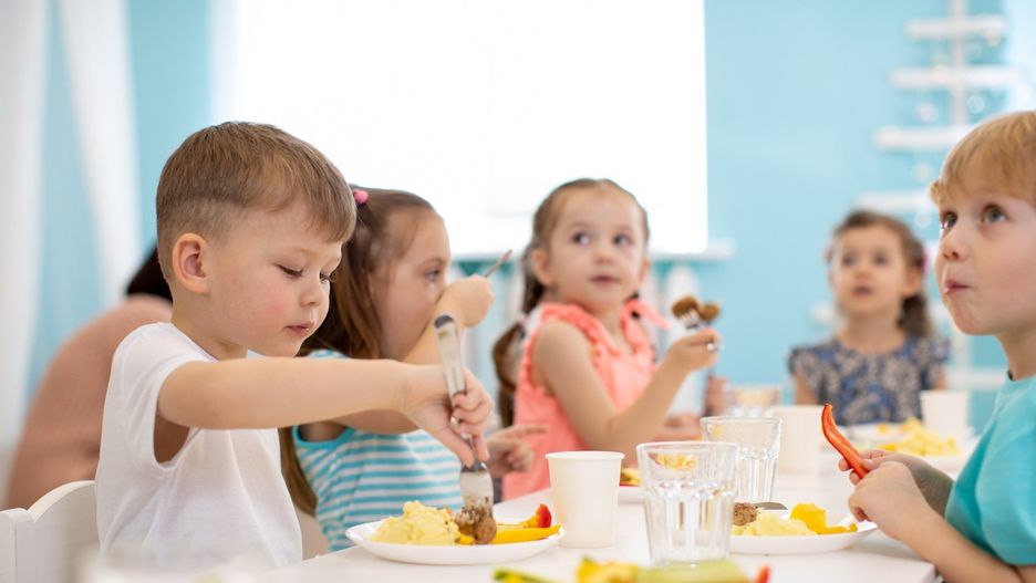 Kids enjoying healthy lunch in kindergarten