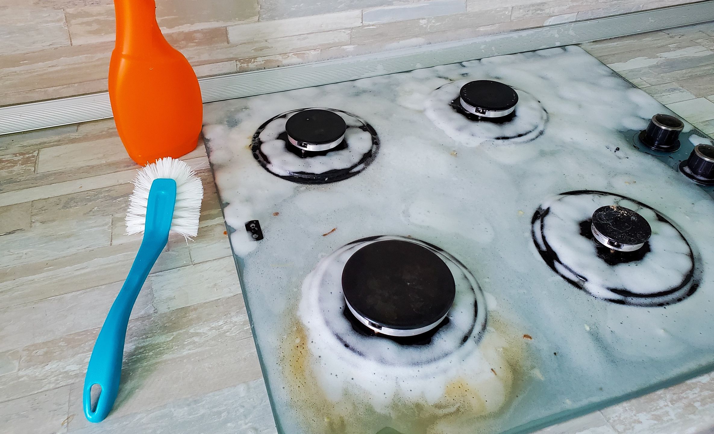 Surface of the gas stove is covered with foam to remove fat and burnt food residuesSurface of the gas stove is covered with foam to remove fat and burnt food residues.stove, gas, cleaning, kitchen, house, cleaner, housework, glass ceramics, dirty, home, household, housewife, detergent, clean, work, rag, hygiene, sponge, washing, bottle, spray, burner, surface, metal, foam, polishing, background, contemporary, cleanser, human, appliance, chemical, working, wash, woman, wet, cooker, glass, oven, care, wipe, cleaning service, rubber, cleanliness, modern, gas stove, hand, purity
