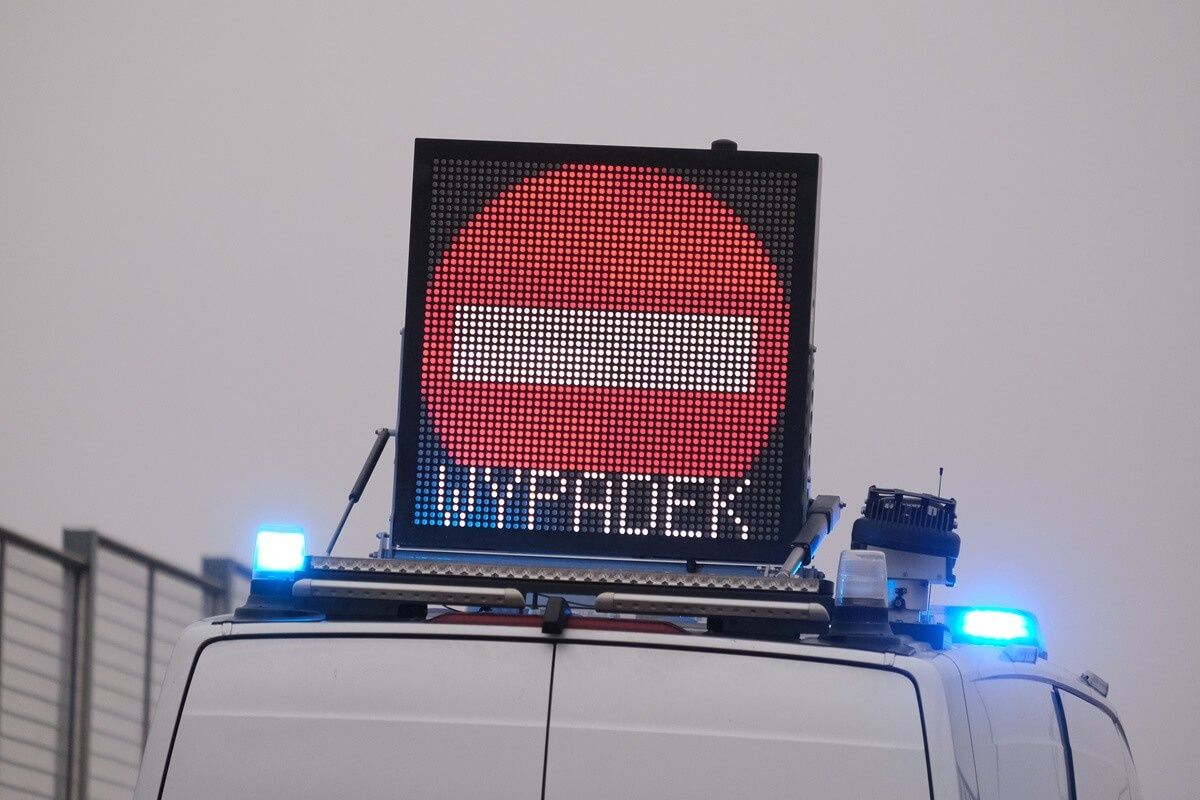 Policyjny radiowóz z tablicą informacyjną "Uwaga Wypadek"
