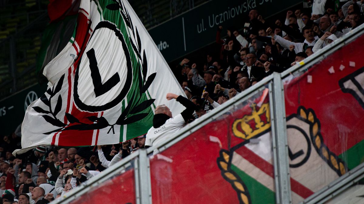 GDANSK, POLAND - OCTOBER 18: Supporters of Legia Warszawa seen with flag on the tribune during PKO Ekstraklasa match between Lechia Gdansk and Legia Warszawa at Polsat Plus Arena on October 18, 2024 in Gdansk, Poland.  (Photo by Mateusz Slodkowski/Getty Images)
