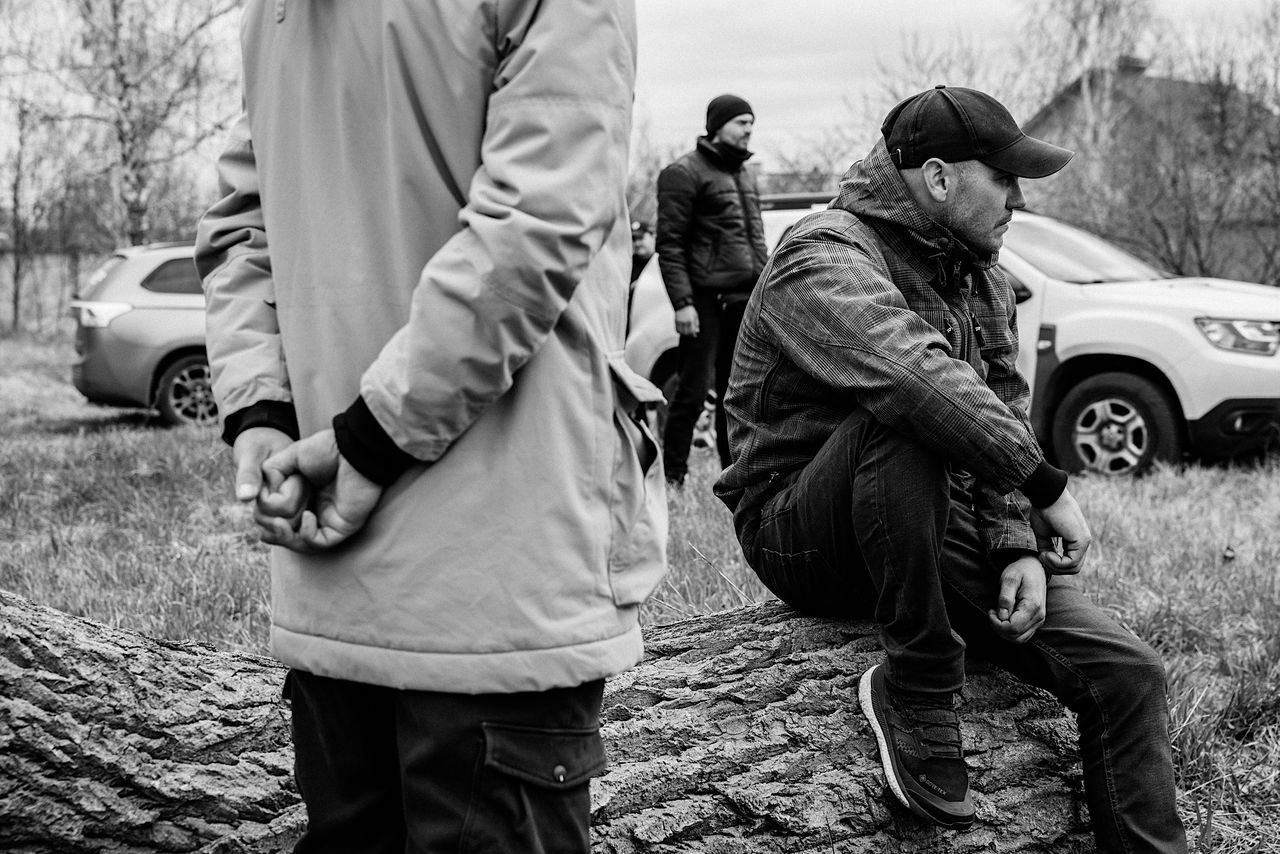 Oleksandr (right) and his brother await their father’s exhumation