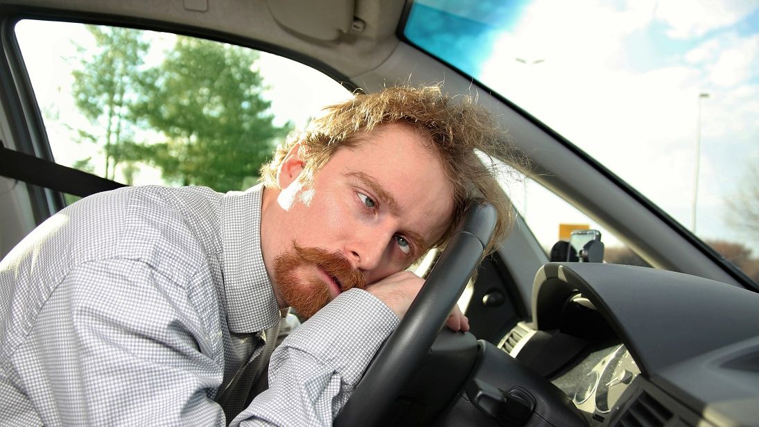 Załamany mężczyzna oparty o kierownicę