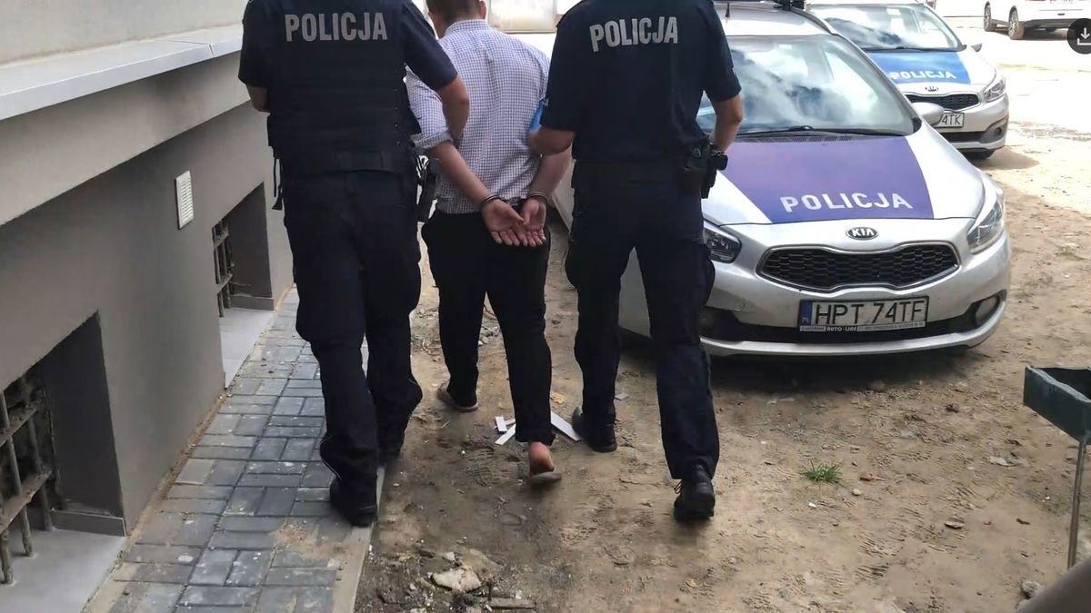 Morderca prowadzony przez dwóch policjantów.