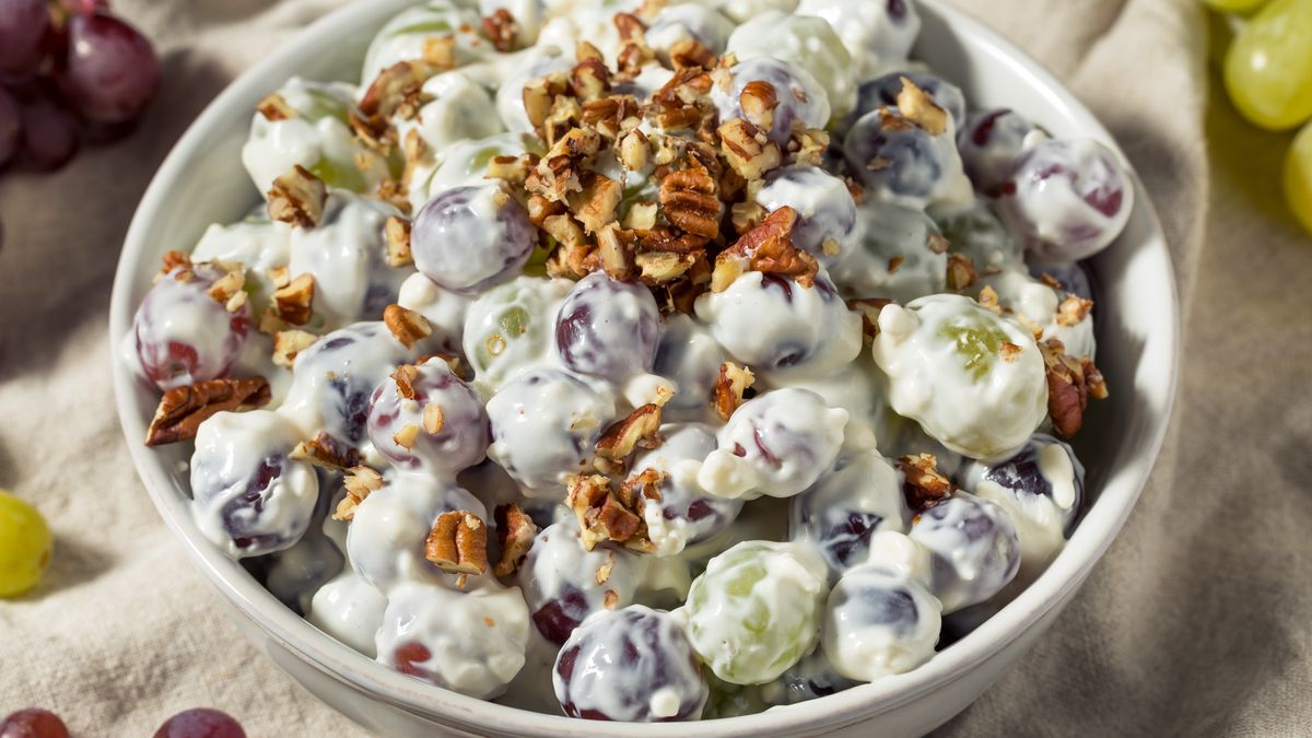 Zdrowa sałatka owocowa otoczona śmietanowym sosem