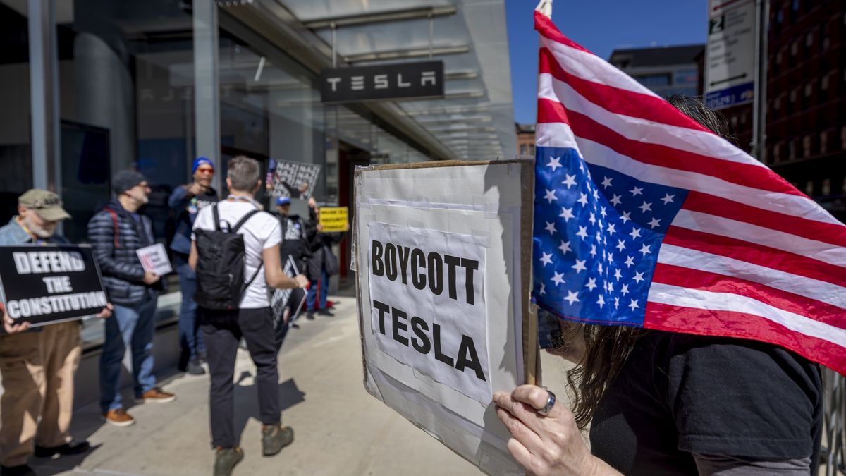 NEW YORK CITY, NEW YORK, UNITED STATES - 2025/03/19: A person holds a sign that reads: "Boycott Tesla" as members of the activist group Rise and Resist read their public statement after being threatened with a federal investigation by the Trump Administration outside a Tesla showroom in lower Manhattan. U.S. Attorney General Pam Bondi has labeled a recent series of attacks on Tesla dealerships across the country as acts of "domestic terrorism" directed at Elon Musk, as Trump allies have pressured the Justice Department to take aggressive action. (Photo by Michael Nigro/Pacific Press/LightRocket via Getty Images)