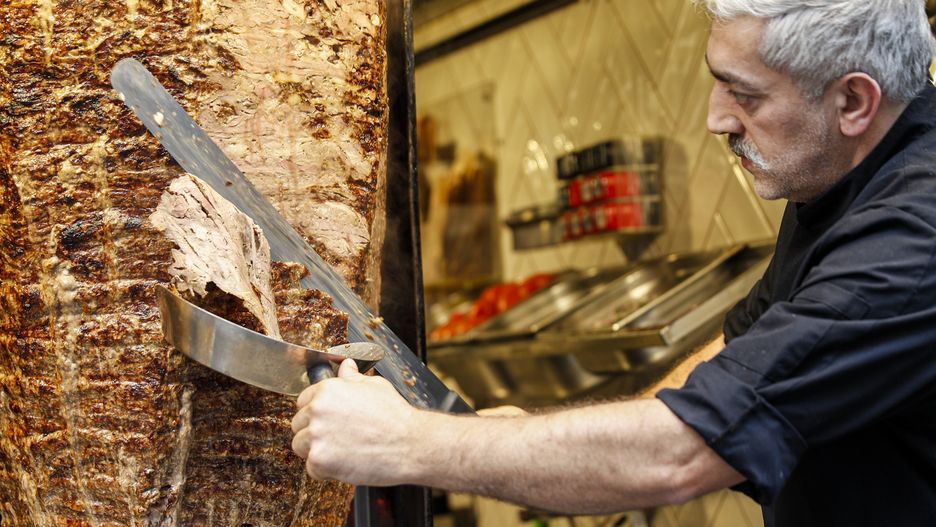 ISTANBUL, March 10, 2022  -- A staff member works at a Turkish doner kebab restaurant in Istanbul, Turkey, March 5, 2022. The streets of Turkey's biggest city Istanbul are filled with a variety of delicious foods, desserts, drinks, attracting Turkish people and tourists.