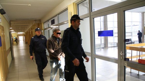 28-letni Krzysztof P. w konwoju policyjnym idzie do sądu