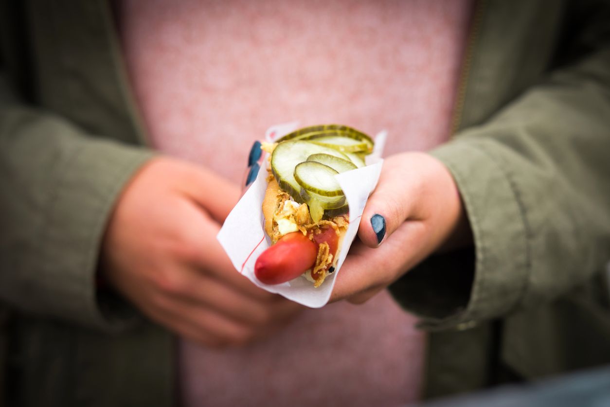 A hot dog in the hands of a girl 