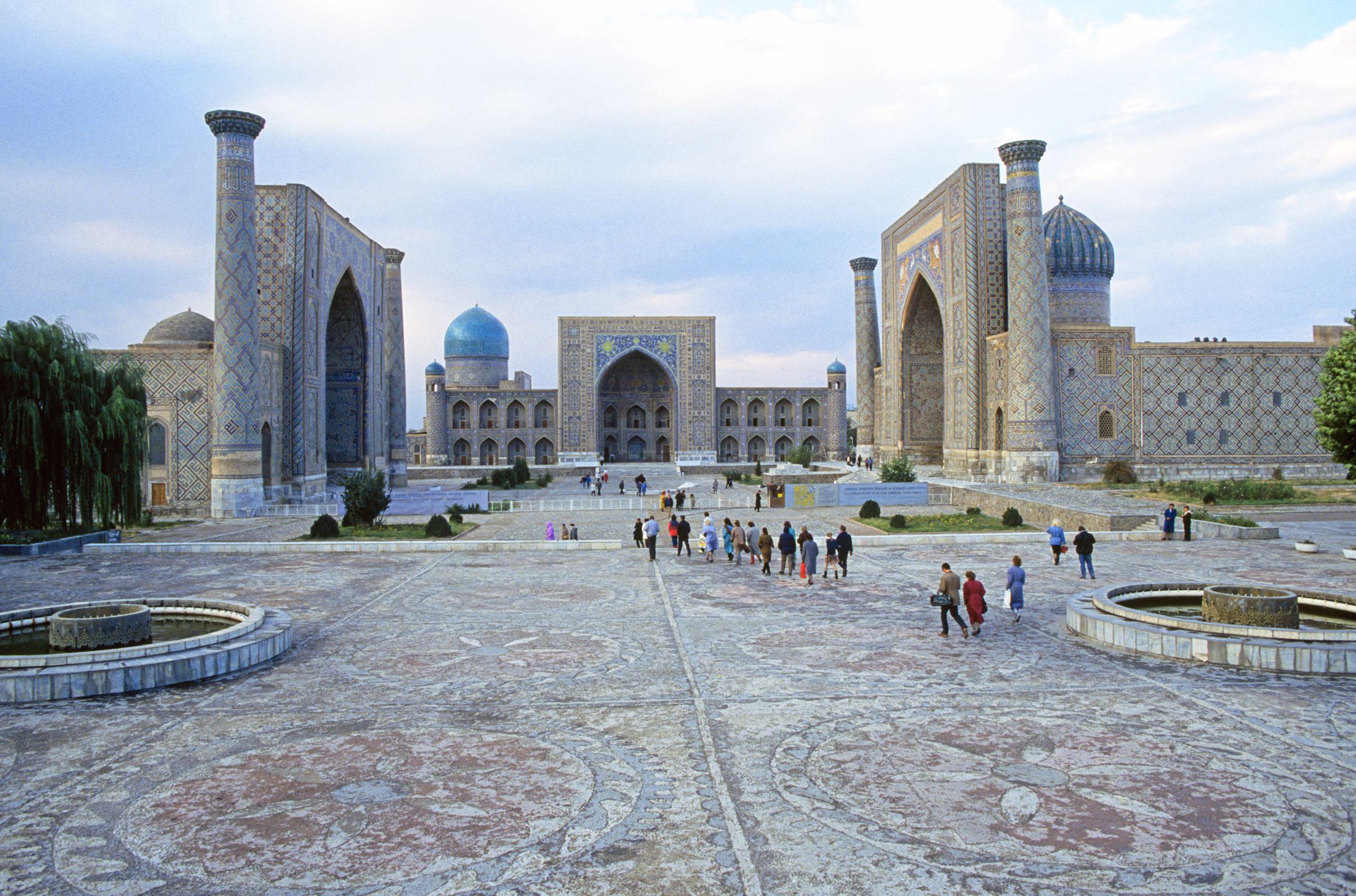 Pilgrims and tourists wander the grounds of the three huge mosque and madrasa, the Ulugh Beg Madrasah (14171420), the Sher-Dor Madrasah (16191636), and the Tilya-Kori Madrasah (16461660), at Registan Square, in the city of Samarkand, Uzbekistan on the Great Silk Road, 2003. (Photo By Buddy Mays/Getty Images).