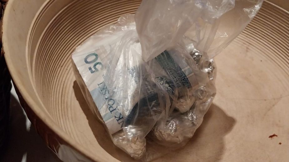 Zawartość plastikowej torby z banknotami i srebrnymi monetami umieszczona w płaskim, okrągłym naczyniu.