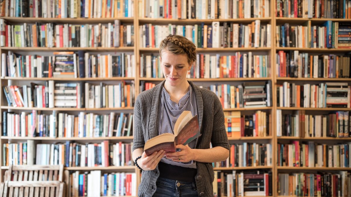 Beautiful young female customer reading book at bookstore
Smiling beautiful young female customer reading book standing against bookshelf at bookstore
Luis Alvarez