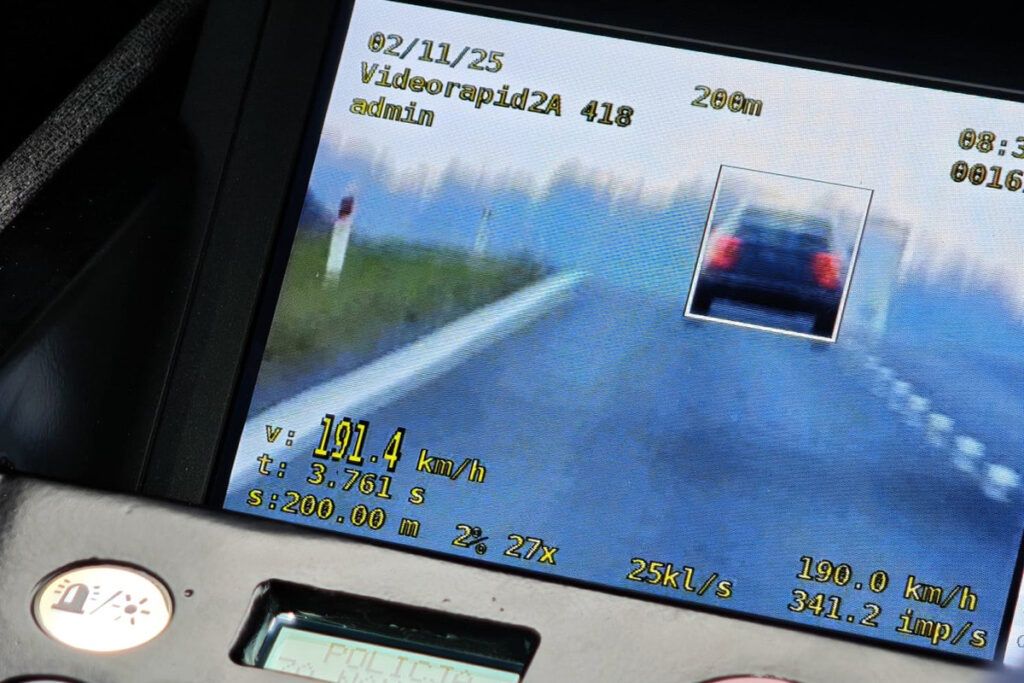 Ekran urządzenia pomiarowego pokazuje prędkość samochodu wynoszącą 191,4 km/h na drodze.
