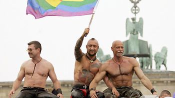 Tęczowa flaga nad uczestnikami parady gejów i lesbijek w Berlinie