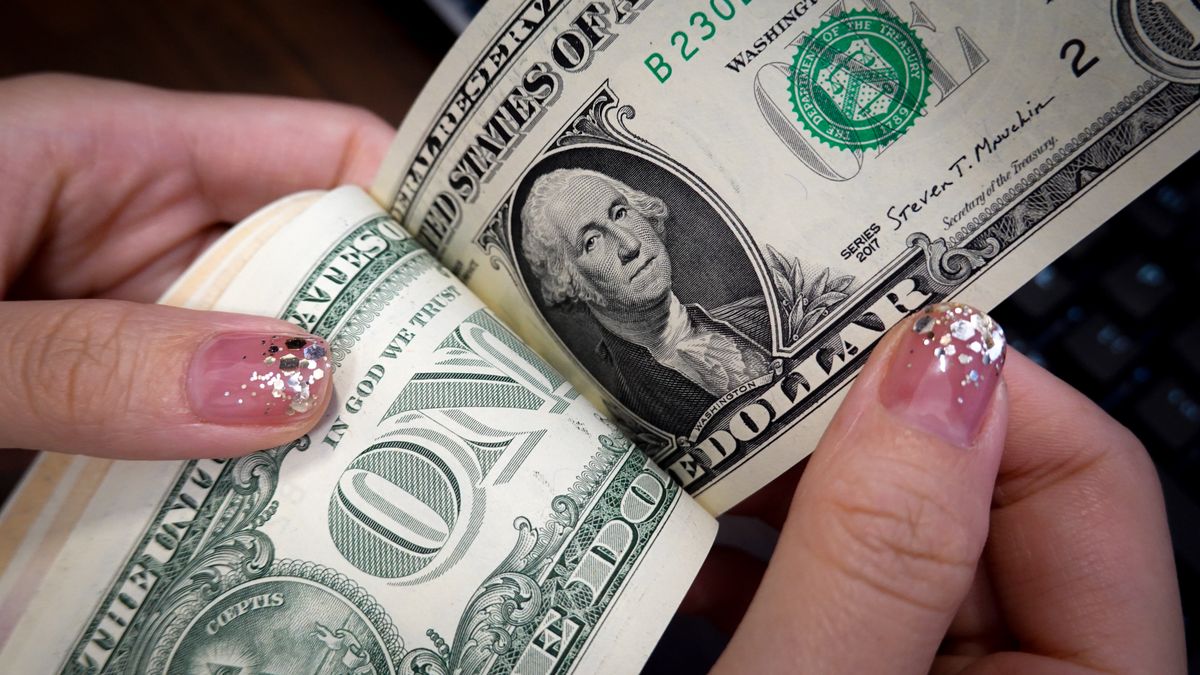 CHINA - 2024/09/15: In this photo illustration, a person counts a stack of one U.S. dollar banknotes. (Photo Illustration by Sheldon Cooper/SOPA Images/LightRocket via Getty Images)