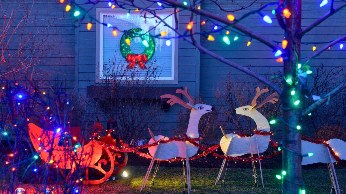 Światełka i sztuczny zaprzęg reniferów przed domem