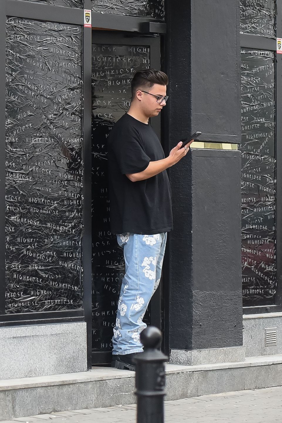 Allan Krupa pali papierosa przed butikiem