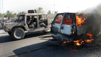 Amerykański pojazd wojskowy płonie na jednej z ulic Bagdadu po wybuchu miny