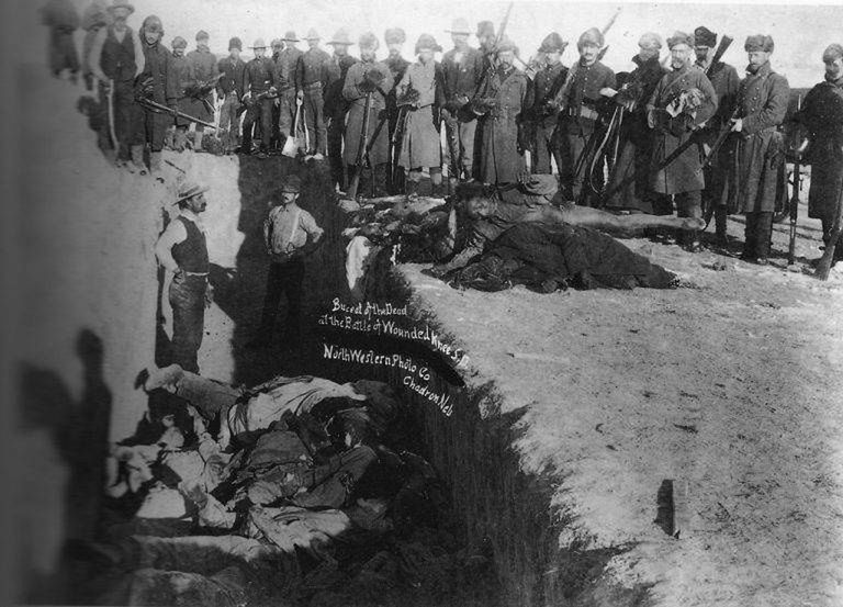 Grzebanie zmarłych po masakrze pod Wounded Knee. Żołnierze amerykańscy składają Indian do wspólnego grobu