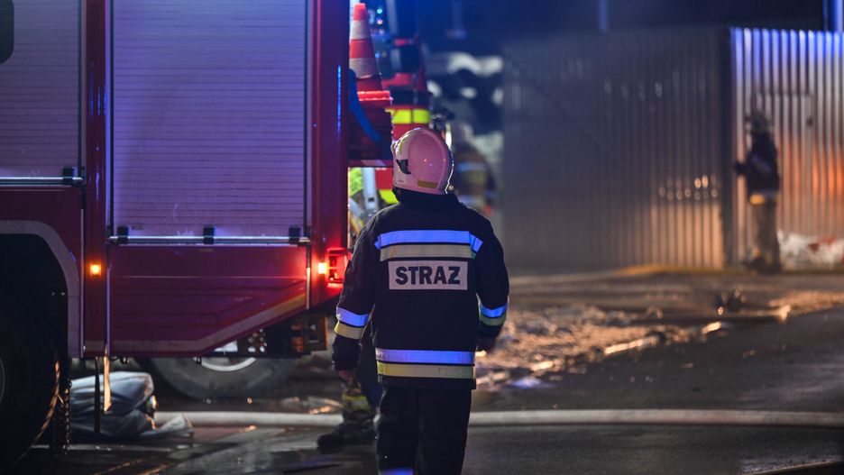 Skawina (pow. krakowski), 24.11.2025. Akcja gaszenia pożaru hali magazynowej przy ul. Torowej w Skawinie, 24 bm. W hali o wymiarach 15 na 100 metrów przechowywany jest m.in. sprzęt oświetleniowy. W akcji uczestniczy ok. 100 strażaków i 22 samochody gaśnicze. Z powodu dużego zadymienia straż pożarna zaleca mieszkańcom zamknięcie okien i niezbliżanie się w okolice pożaru. (jm) PAP/Art Service ***Do tego materiału zdjęciowego dostępna jest również depesza w systemie CSI, pt.: Małopolskie/ Płonie hala magazynowa w Skawinie, straż zaleca zamknięcie okien***