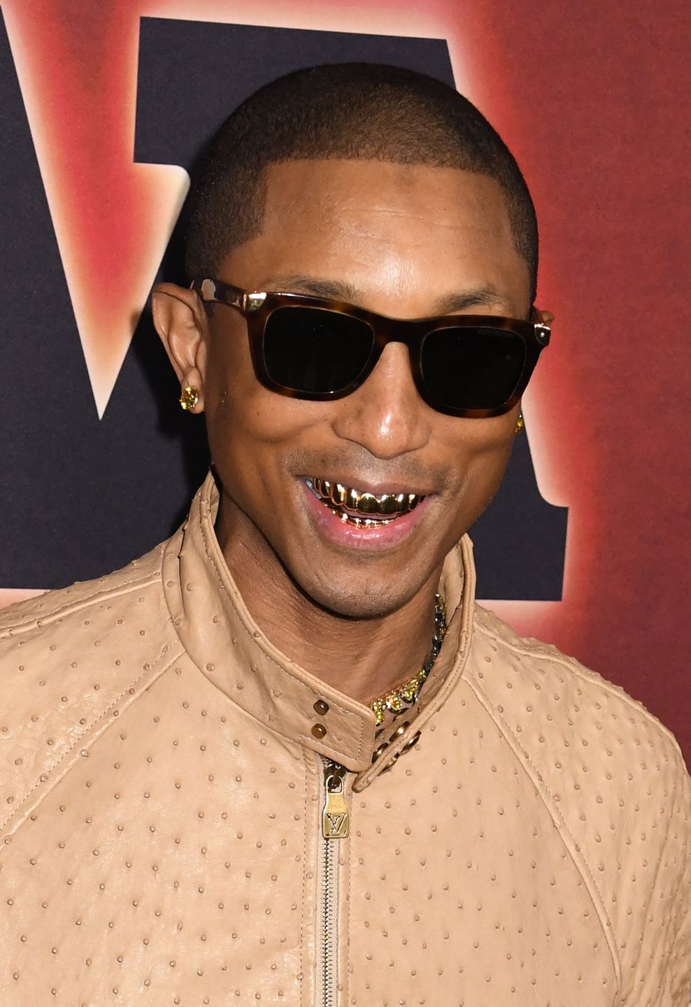 Pharrell Williams oślepia złotym uśmiechem na ściance