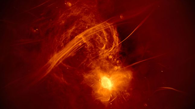 Ten jasny obiekt to Sagittarius A*, znajdujący się w sercu naszej galaktyki.  Astronomowie uważają, że jest to supermasywna czarna dziura. Jasnożółty kolor reprezentuje ogromną ilość emisji radiowych z materii, który jest zasysana przez obiekt.