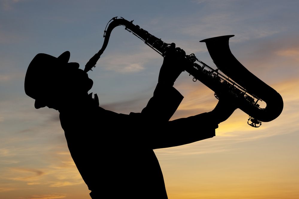 zdjęcie: Saxophonist. Man playing on saxophone against the background of sunset