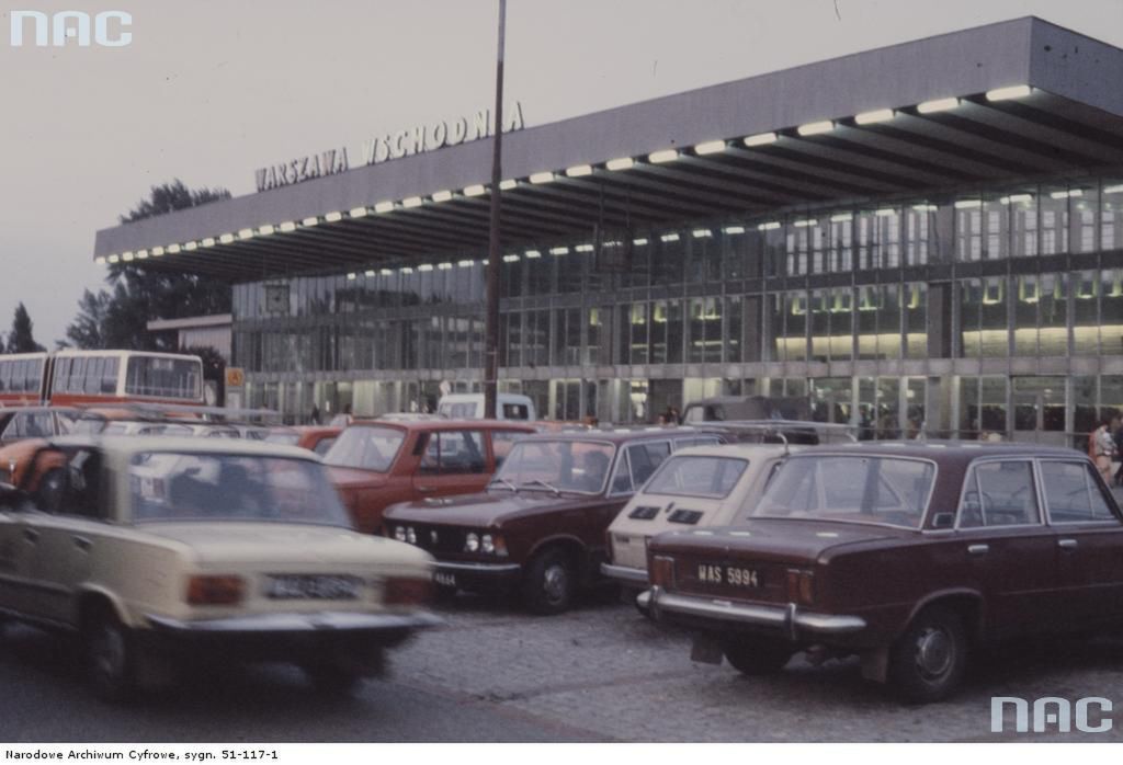 Widok zewnętrzny budynku Dworca Wschodniego w Warszawie. Widoczne samochody - Fiat 125p, Fiat 126p i Wartburg 353 zaparkowane przed budynkiem.