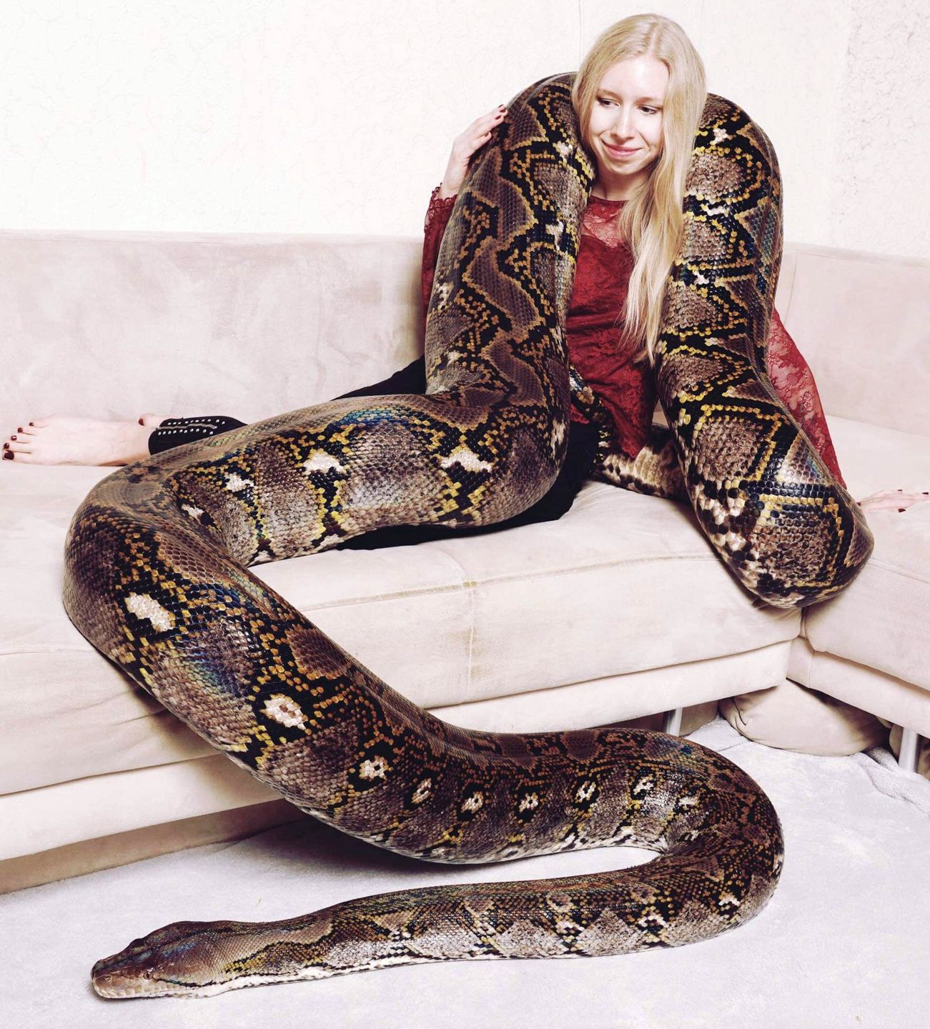 Kobieta pozuje z wielkim wężem.
