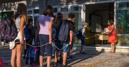 Zdjęcie dnia. Powrót do szkół we Włoszech, czyli maseczki i sznurek w kolejce