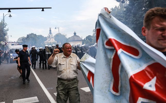 Po przerwaniu przez policję blokady Parady Równości w Białymstoku dwaj mężczyźni trzymają baner z napisem "Mama i tata największym skarbem świata", 20 lipca 2019