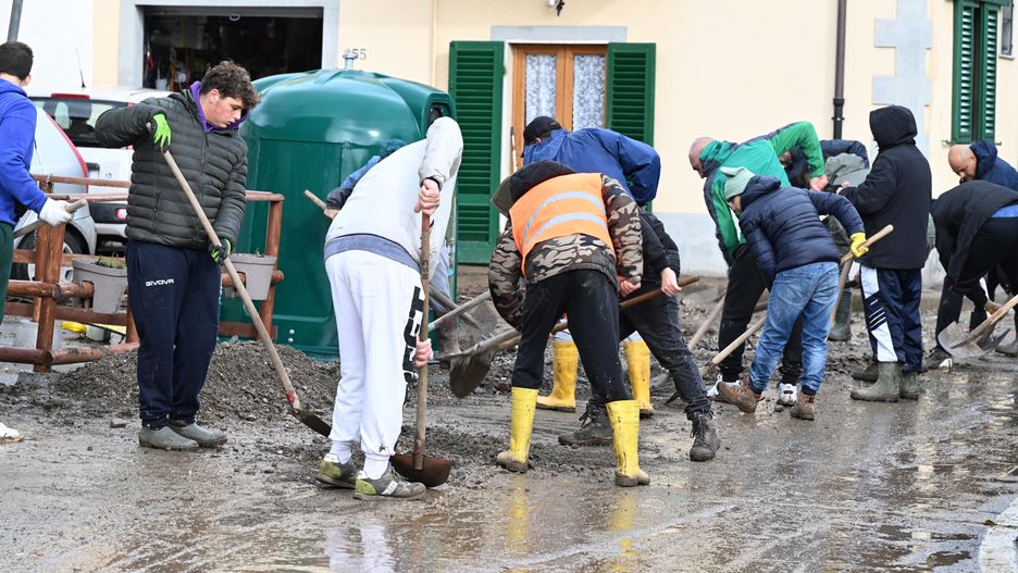 Ochotnicy usuwają błoto z włoskich ulic