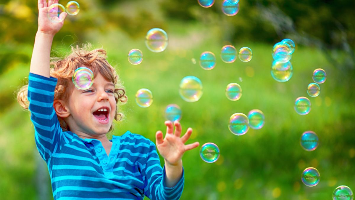 Chłopiec łapie bańki mydlane