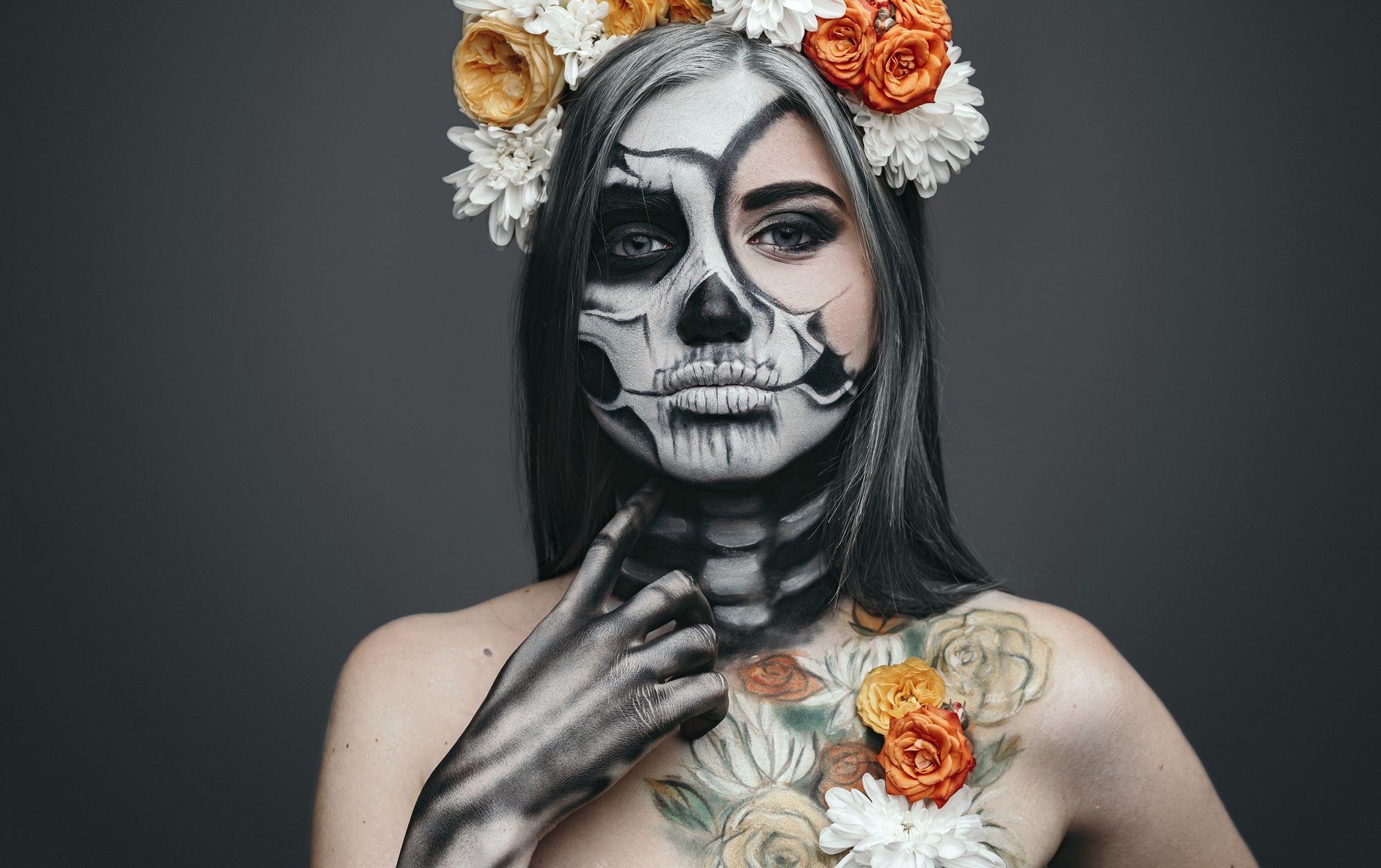 Pretty female with floral wreath and body artYoung woman with artistic spooky makeup and fresh flowers on head standing prepared for Halloween party touching painted neck and looking at camerawoman, halloween, makeup, body art, flower, spooky, disguise, dead, skeleton, skull, creepy, female, terrifying, frightening, scary, serious, thoughtful, naked, wreath, ritual, traditional, holiday, colorful, fresh, rose, floral, chrysanthemum, bright, painted, face, black, white, culture, evil, ghost, zombie, party, horror, celebration, carnival, artistic, decorative, autumn, fantasy, folklore, looking at camera, black background, horizontal, copy space, studio shot, woman, halloween, makeup, body art, flower, spooky, disguise, dead, skeleton, skull, creepy, female, terrifying, frightening, scary, serious, thoughtful, naked, wreath, ritual, traditional, holiday, colorful, fresh, rose, floral, chrysanthemum, bright, painted, face, black, white, culture, evil, ghost, zombie, party, horror, celebration, carnival, artistic, decorative, autumn, fantasy, folklore, looking at camera, black background, horizontal, copy space, studio shot