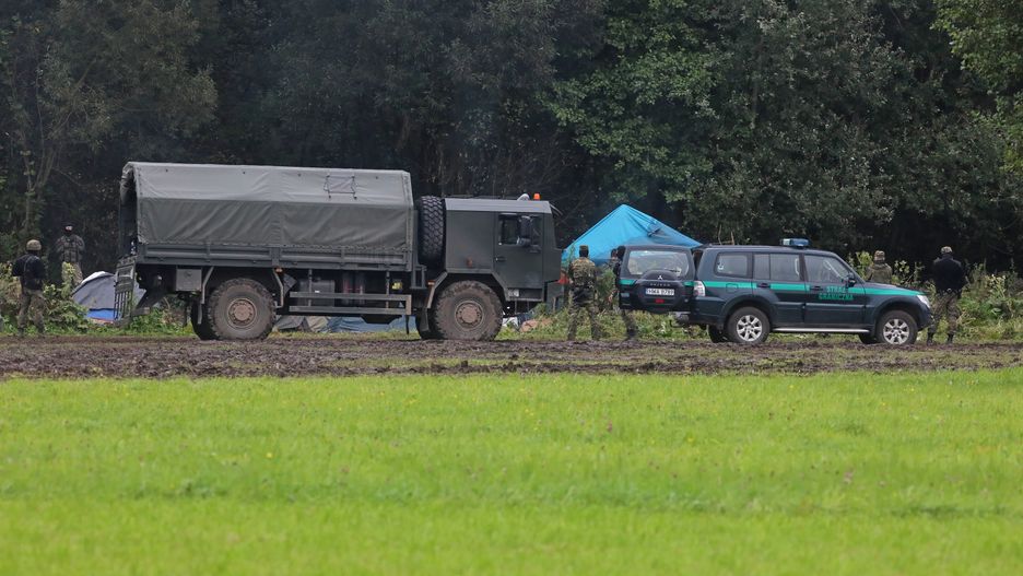 Usnarz Górny (pow. sokólski), 30.08.2021. Straż graniczna i wojsko na polsko-białoruskiej granicy w pobliżu miejscowości Usnarz Górny, 30 bm. Mija kolejny dzień, w którym grupa cudzoziemców koczuje na granicy polsko-białoruskiej. Przejścia na polską stronę pilnują żołnierze i funkcjonariusze SG. Natomiast z białoruskiej strony przed ewentualnym odwrotem zagradzają im drogę tamtejsze służby. (ar/amb) PAP/Artur Reszko