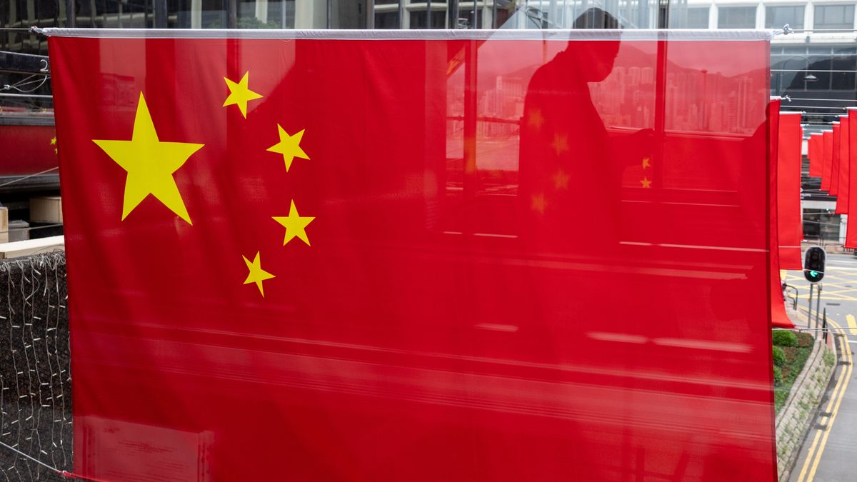 A man is reflected in a window as the flags of the Peopleâ��s Republic of China and of the Hong Kong SAR are displayed in a street in Hong Kong, China, 20 June 2022. On 01 July 2022 Hong Kong will celebrate the transfer of sovereignty over Hong Kong from the United Kingdom to the People's Republic of China and the establishment of the Hong Kong Special Administrative Region. EPA/JEROME FAVRE Dostawca: PAP/EPA.