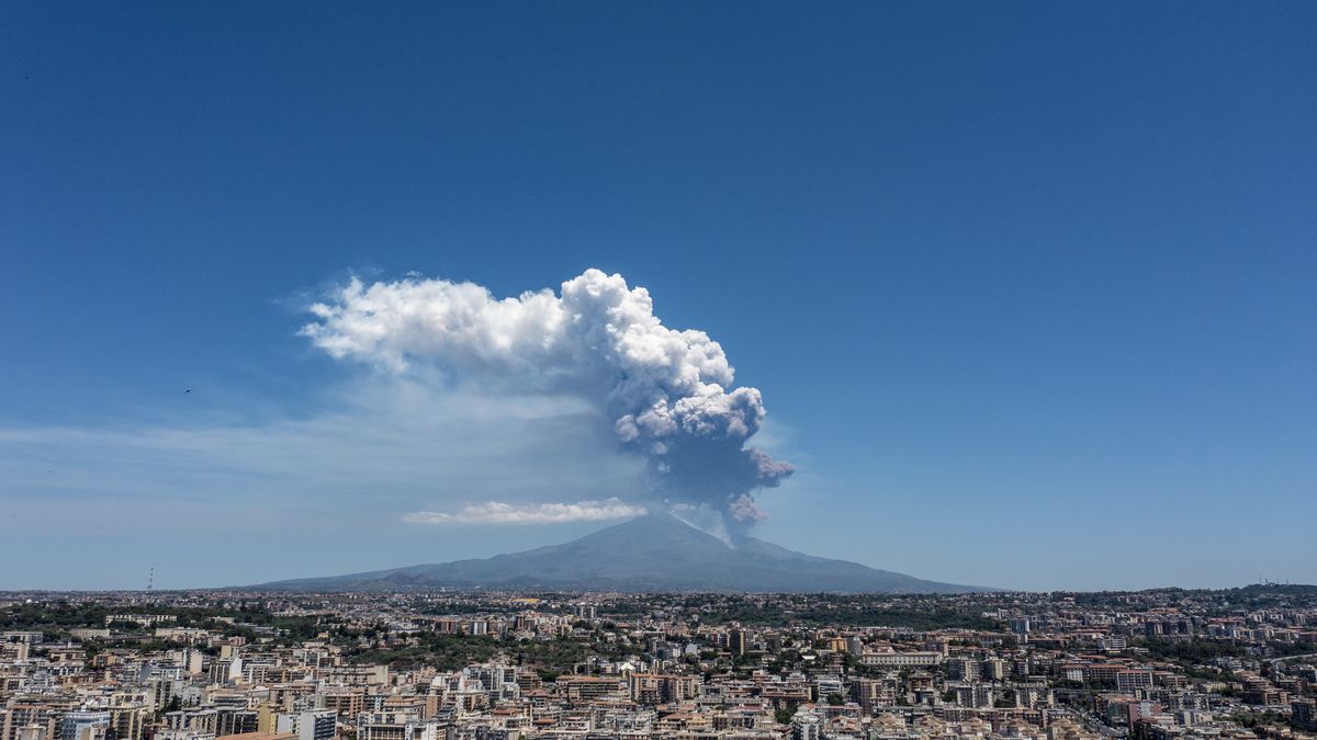 CATANIA, ITALY - JUNE 02: Mount Etna exhibits a Strombolian eruption, with a volcanic plume rising from the southeast crater, on June 02, 2025 in Catania, Italy. An orange aviation warning has been issued. The images show aerial views of the volcano with the city of Catania in the background. (Photo by Fabrizio Villa/Getty Images)